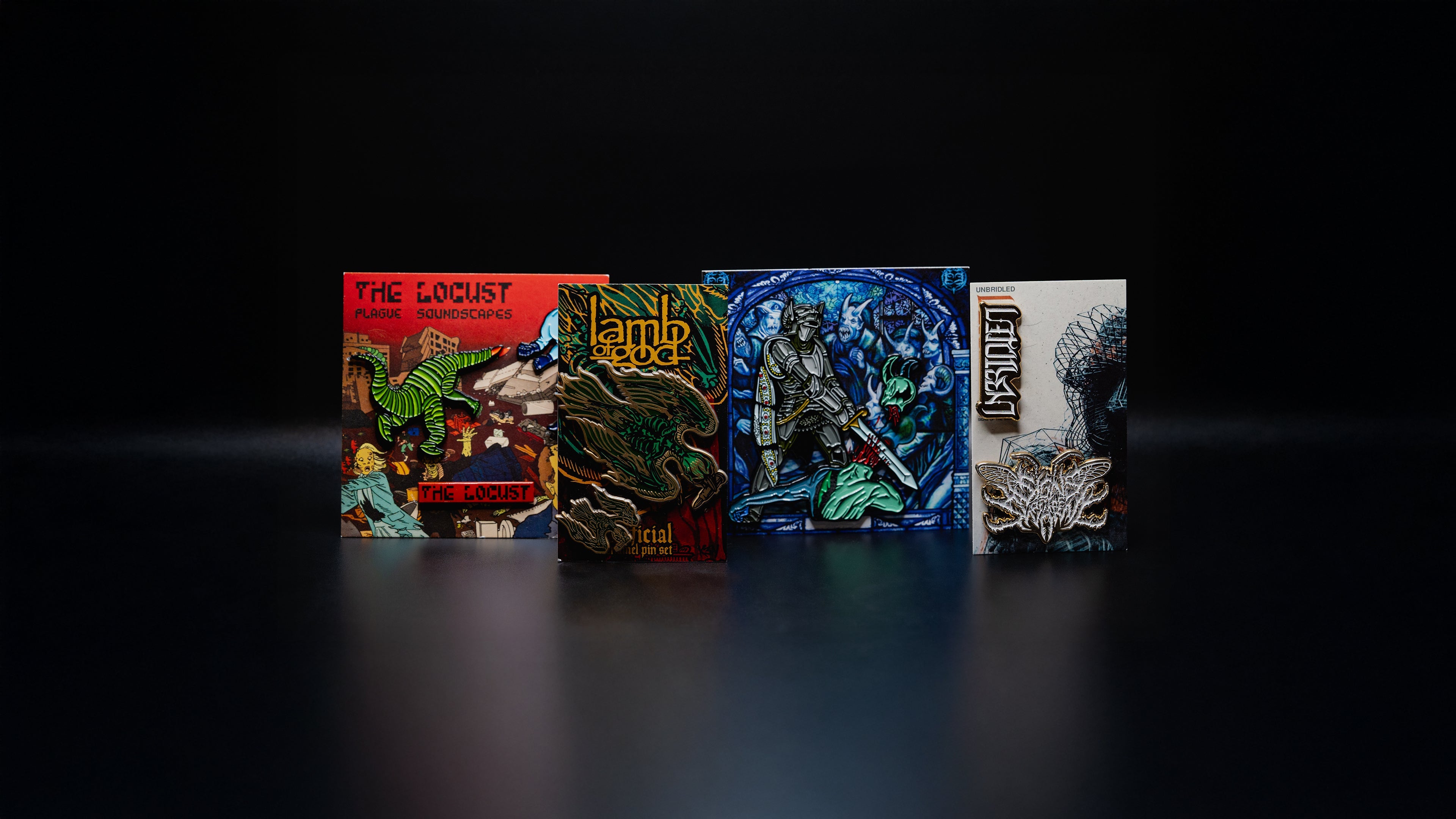 Display of limited edition band pins on colorful backing cards against a dark reflective background
