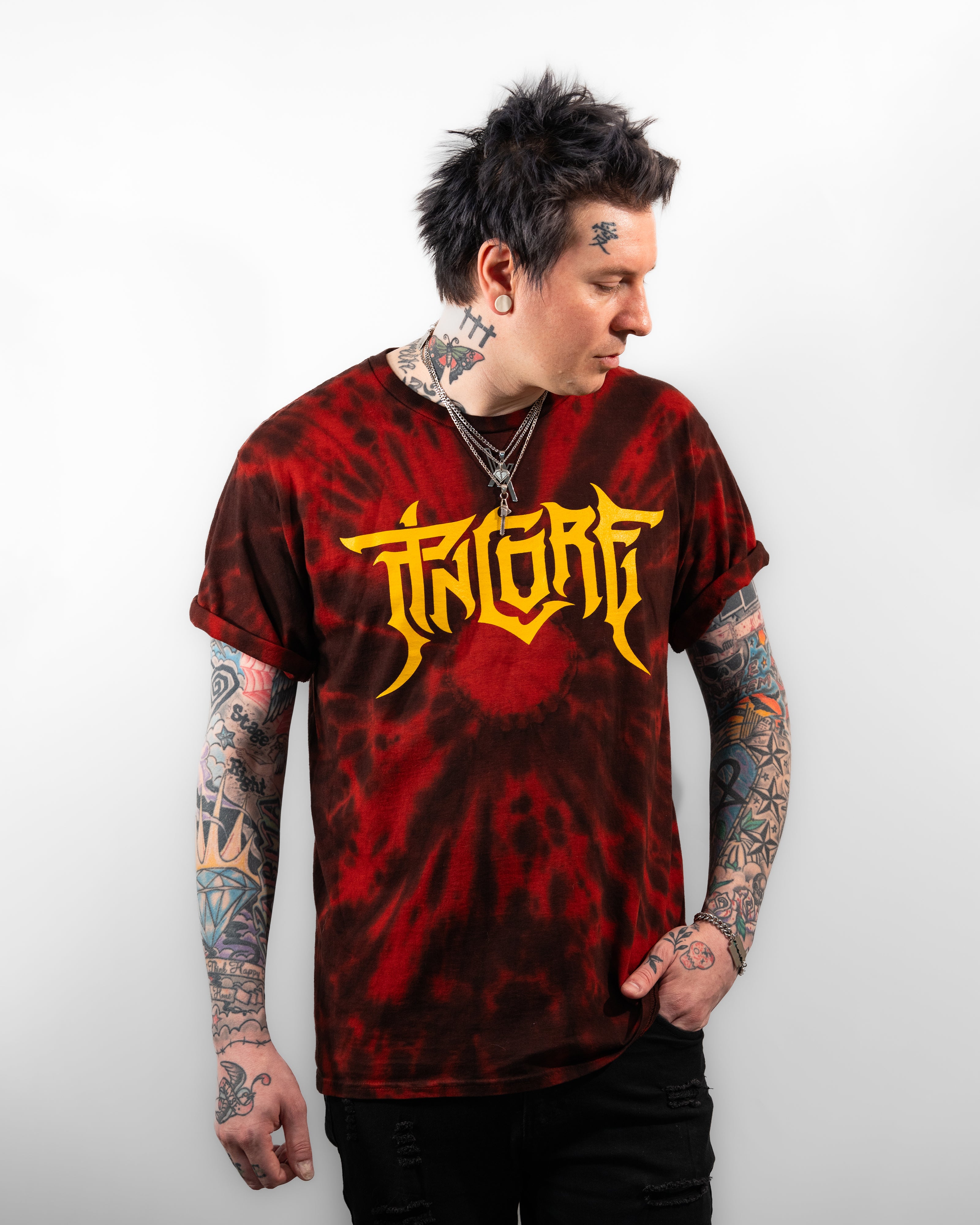 Red tie-dye T-Shirt with yellow Pincore logo on front worn by tattooed male model in black jeans