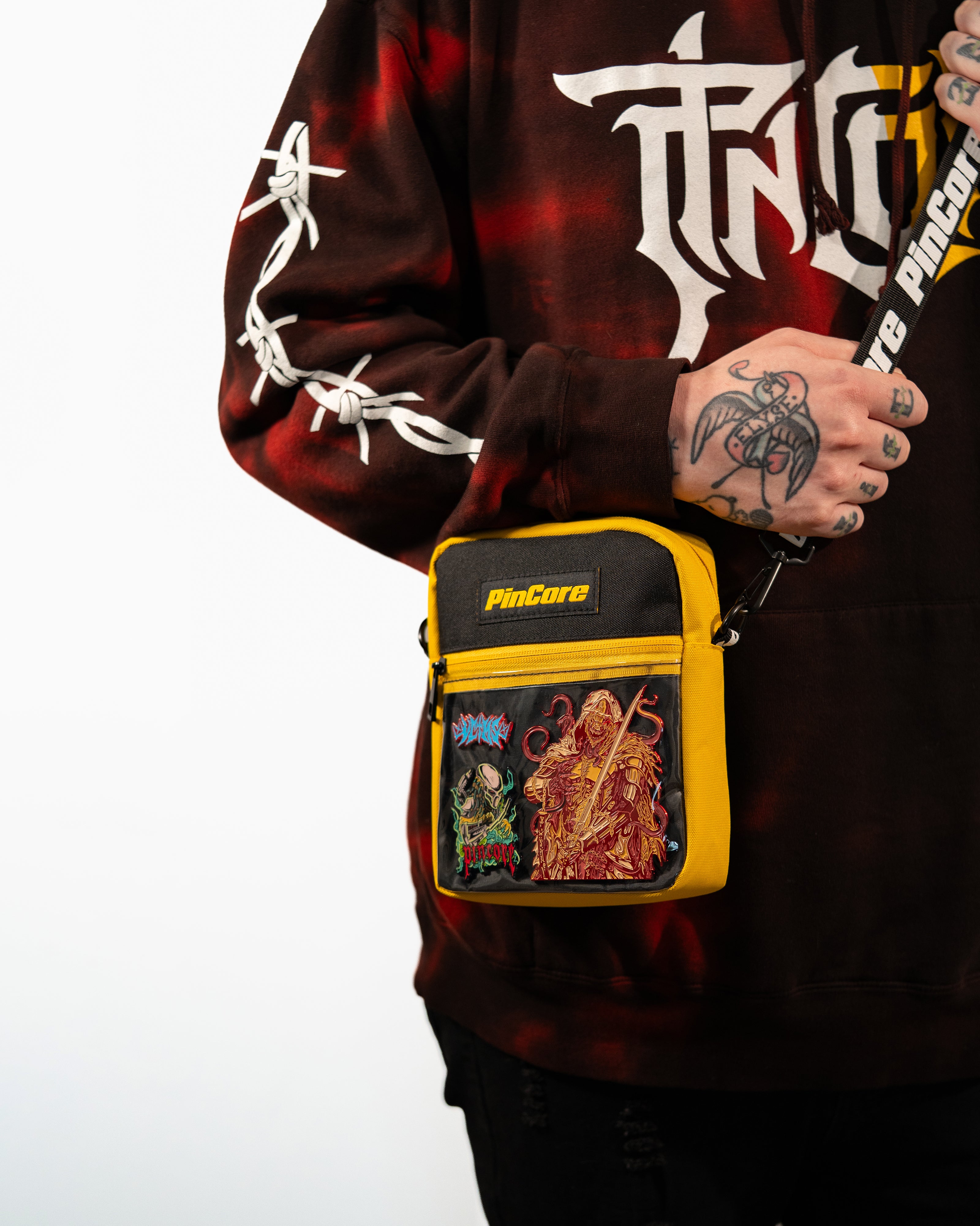 Image of Pincore Merchandise yellow and black pin display shoulder bag worn crossbody showing enamel pins