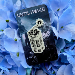 Image of Until I Wake enamel pin by Pincore Merchandise featuring stylized dynamite barcode design on floral background